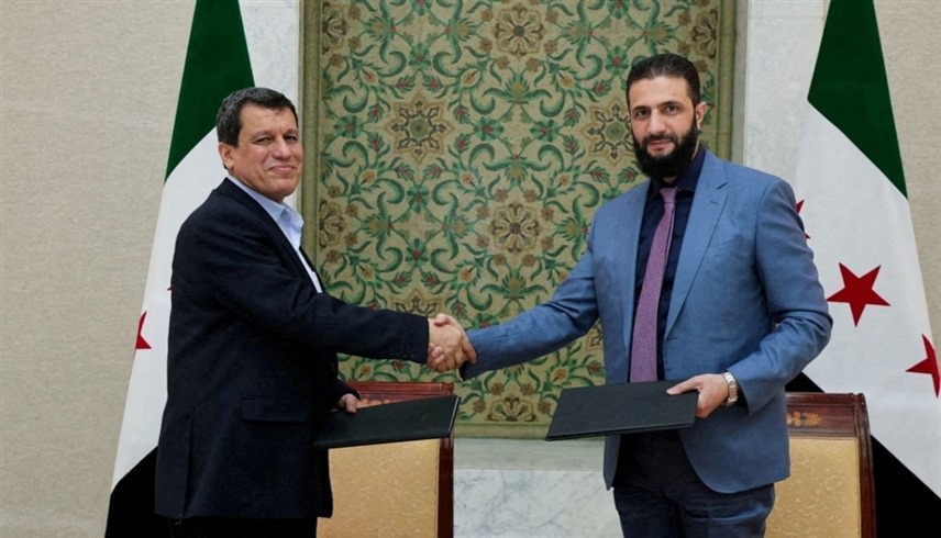 الشرع يصافح عبدي خلال توقيع اتفاق مارس 2025 (أ ف ب)