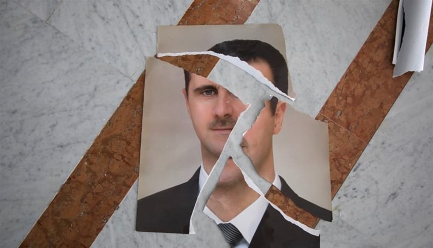 صورة ممزقة لبشار الأسد بعد سقوط نظامه في سوريا (أرشيف)