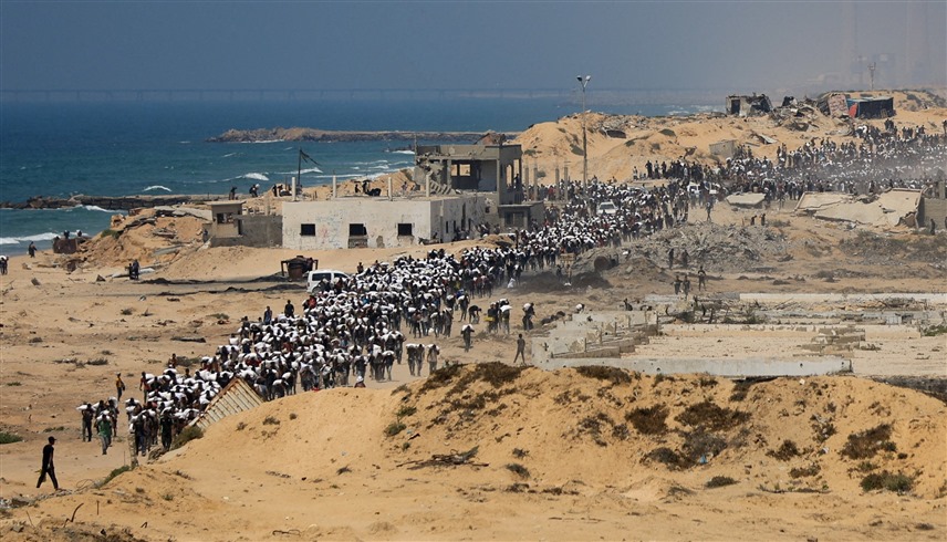 آلاف الفلسطينيين خلال الحصول على مساعدات إنسانية في غزة (رويترز)