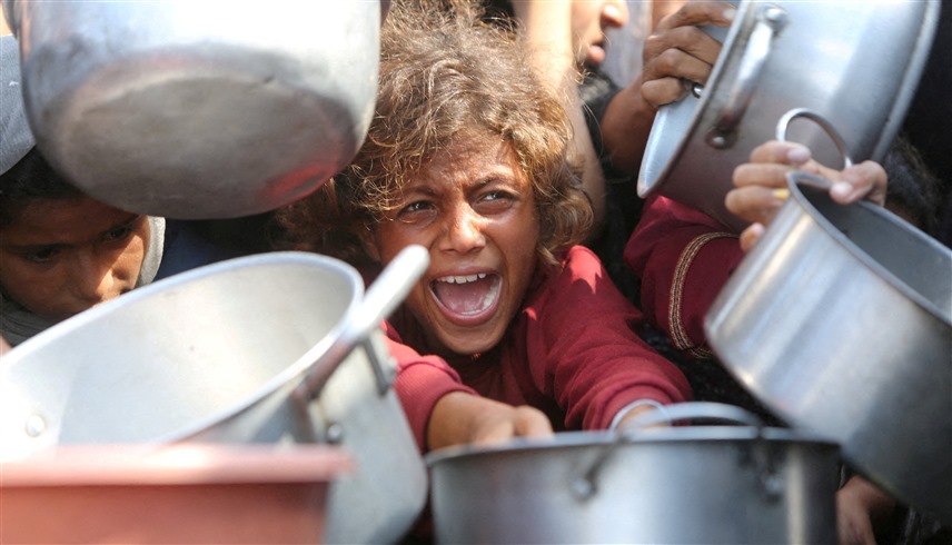فلسطينيون يحاولون الحصول على الطعام في غزة (رويترز)